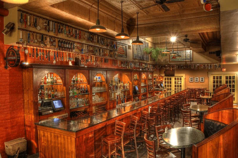 Pearly Baker's Alehouse bar interior — mahogany back bar, tin ceiling, pendant lights